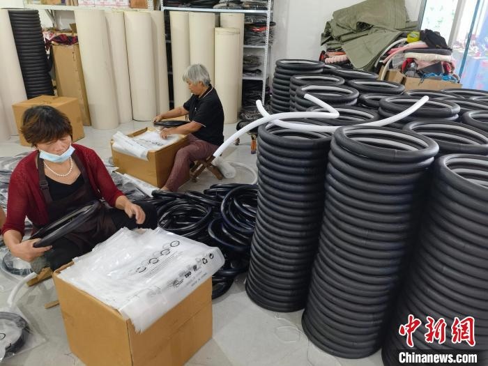圖為村民在汽車飾品企業(yè)生產(chǎn)車間中工作?！巫雍?攝