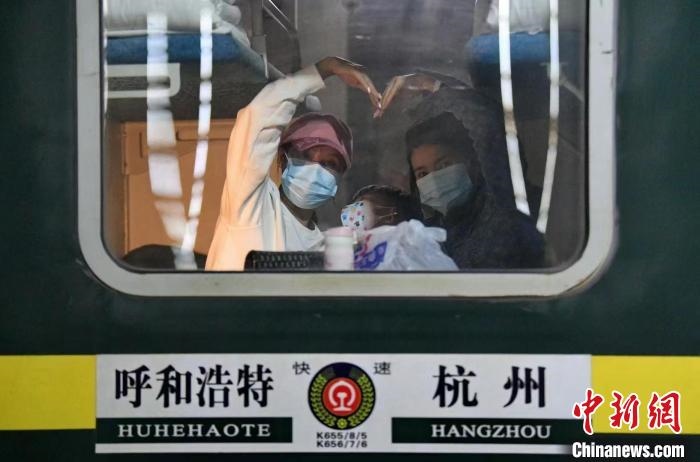 圖為登上轉(zhuǎn)運火車的游客向額濟納比心?！⊥趵?攝