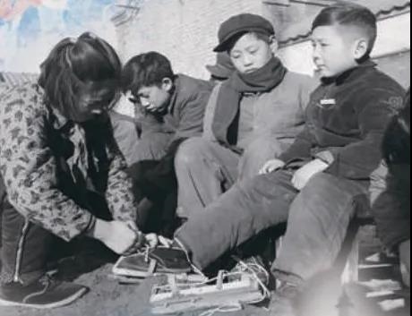 上世紀(jì)50年代，孩子們?cè)诖┠景灞?圖源：北京日?qǐng)?bào))