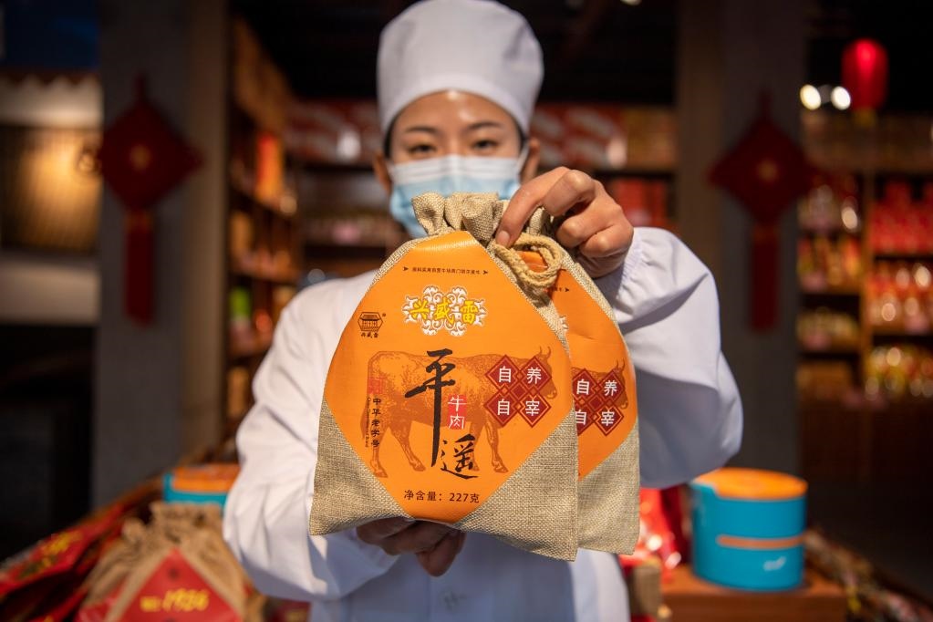 1月27日，在平遙古城南大街的一家平遙牛肉店內(nèi)，工作人員展示一款牛肉產(chǎn)品。新華社記者 楊晨光 攝
