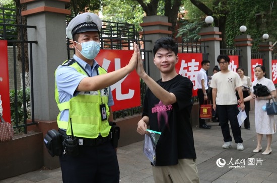 6月7日8時許，武漢中學(xué)考點門口，交警在維護(hù)秩序，并祝考生金榜題名。人民網(wǎng)記者 肖璐欣攝
