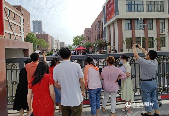 6月7日，武漢市第三中學(xué)考點，考生進(jìn)場后，家長在柵欄外用手機(jī)拍攝自己的孩子。人民網(wǎng)記者 郭婷婷攝