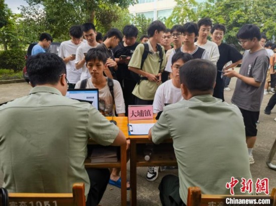 專武干部在發(fā)放兵役登記證。韋碩 攝