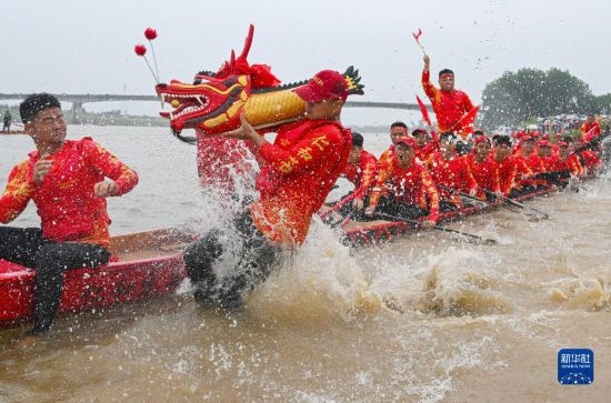 6月22日，在湖南省岳陽市湘陰縣湘江臨資口水域，參加龍舟賽的隊員接“龍頭”下水。