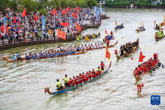 6月23日，在貴州省黔東南苗族侗族自治州施秉縣舉行的獨(dú)木龍舟節(jié)上，獨(dú)木龍舟進(jìn)行水上巡游。