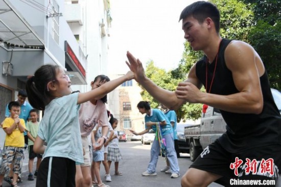 圖為大學(xué)生志愿者在組織孩子們參加體育健身活動(dòng)。廖光福 攝
