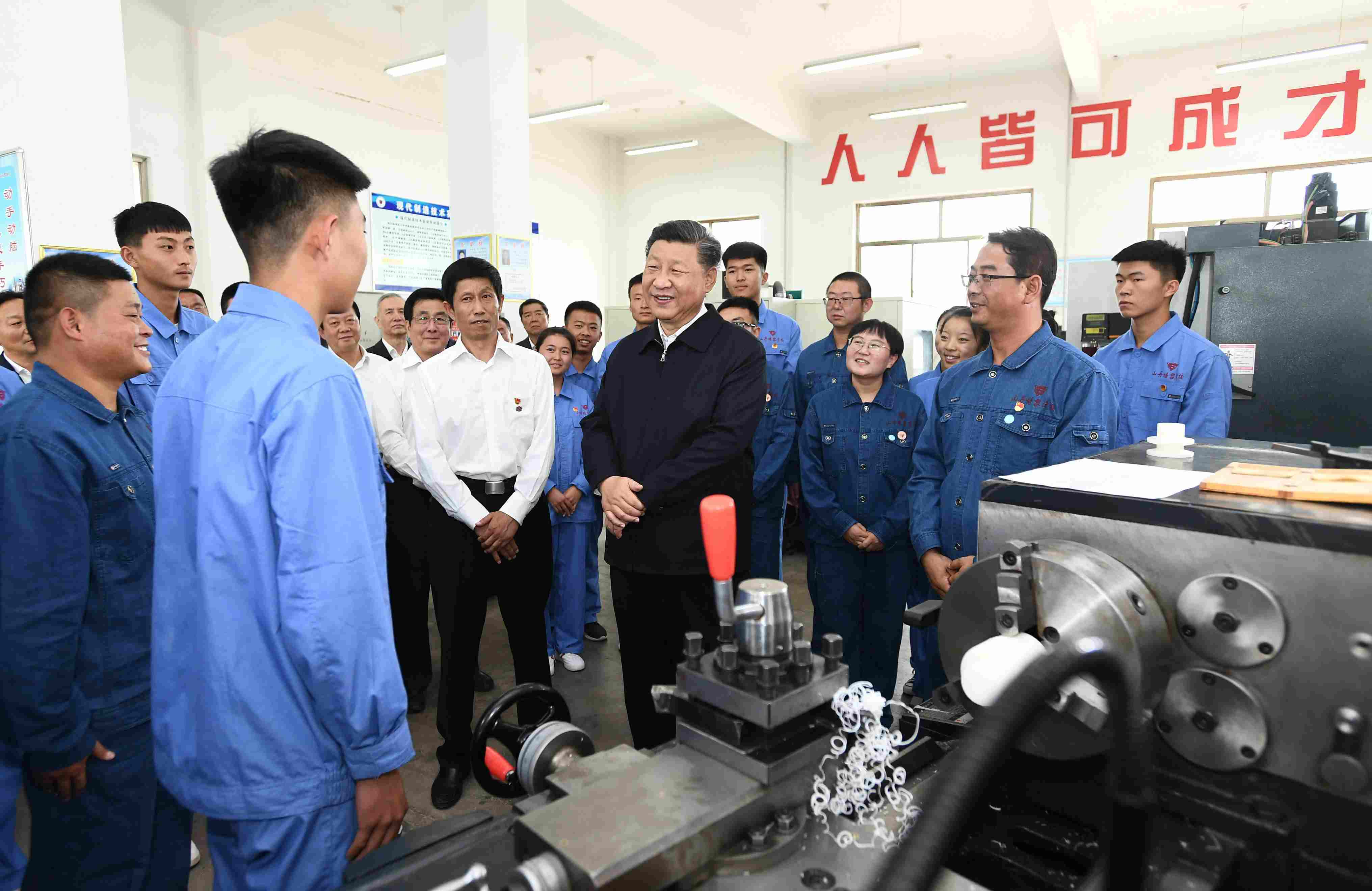 2019年8月20日，習(xí)近平在甘肅省張掖市山丹培黎學(xué)校現(xiàn)代制造技術(shù)實(shí)訓(xùn)室，觀看職業(yè)技能實(shí)訓(xùn)，同師生親切交流。
