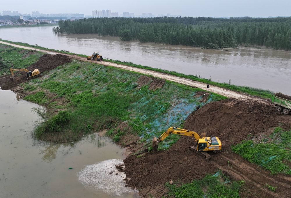 工人操作機(jī)械在白溝河左堤白溝新城高橋村段進(jìn)行除險(xiǎn)加固作業(yè)（8月4日攝，無(wú)人機(jī)照片）。新華社記者 朱旭東 攝