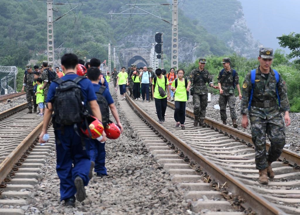 8月2日，部分滯留在北京市門頭溝山區(qū)受困列車的旅客，在救援人員幫助下前往轉(zhuǎn)運(yùn)客車。新華社記者張晨霖 攝
