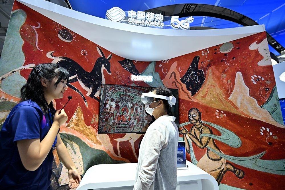 9月3日，一名參觀者在首鋼園中國移動展臺體驗(yàn)基于AR/VR特效的敦煌導(dǎo)覽，沉浸式感受敦煌壁畫的魅力。新華社記者 李鑫 攝