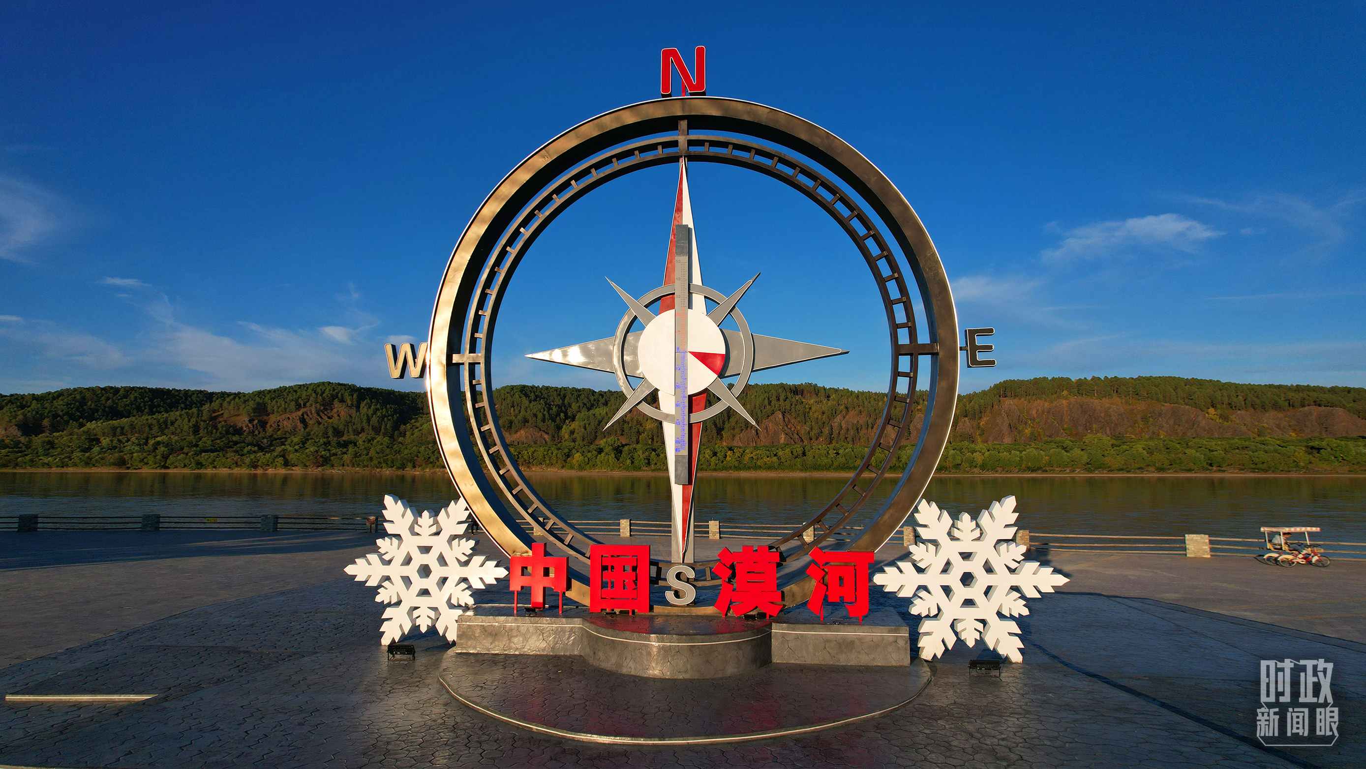 △指北針雕塑是北極村標志性建筑之一，其紅色指針指向正北方。上面的大型溫度計高12.22米，象征北極村位于東經(jīng)122°20′。（總臺央視記者范凱拍攝）