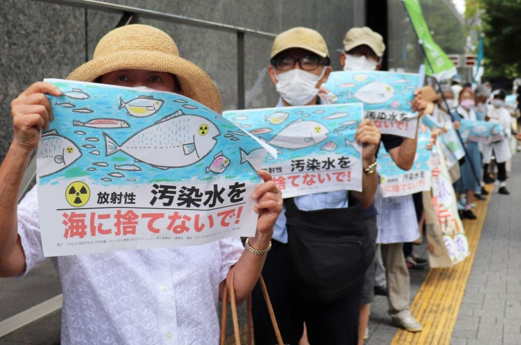 8月24日，日本民眾手持“不要將污染水扔進(jìn)大?！钡葮?biāo)語在東京電力公司總部前集會，抗議日本政府和東電公司無視民意啟動核污染水排海。新華社記者楊光攝