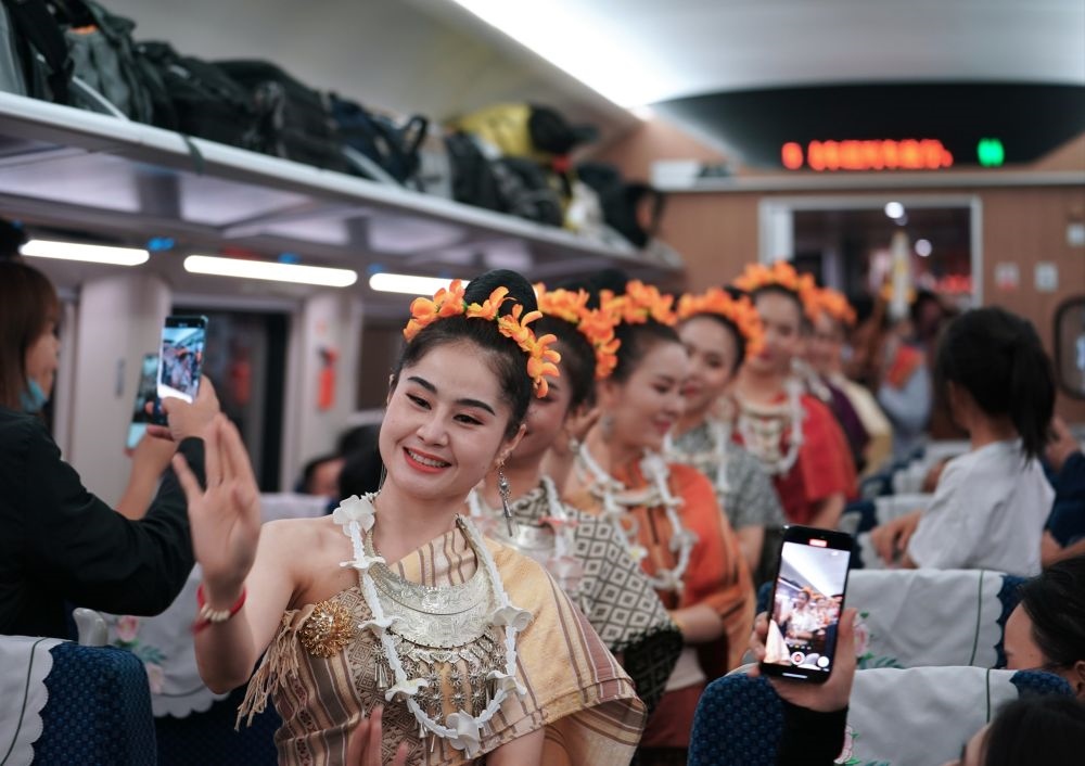 2023年4月13日，老撾工作人員在中老鐵路上開(kāi)行的D887次國(guó)際旅客列車(chē)上表演。新華社記者 邢廣利 攝