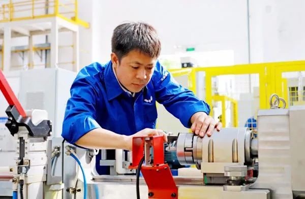 △鄭志明正在對襯套自動壓裝設(shè)備進行檢測調(diào)試。