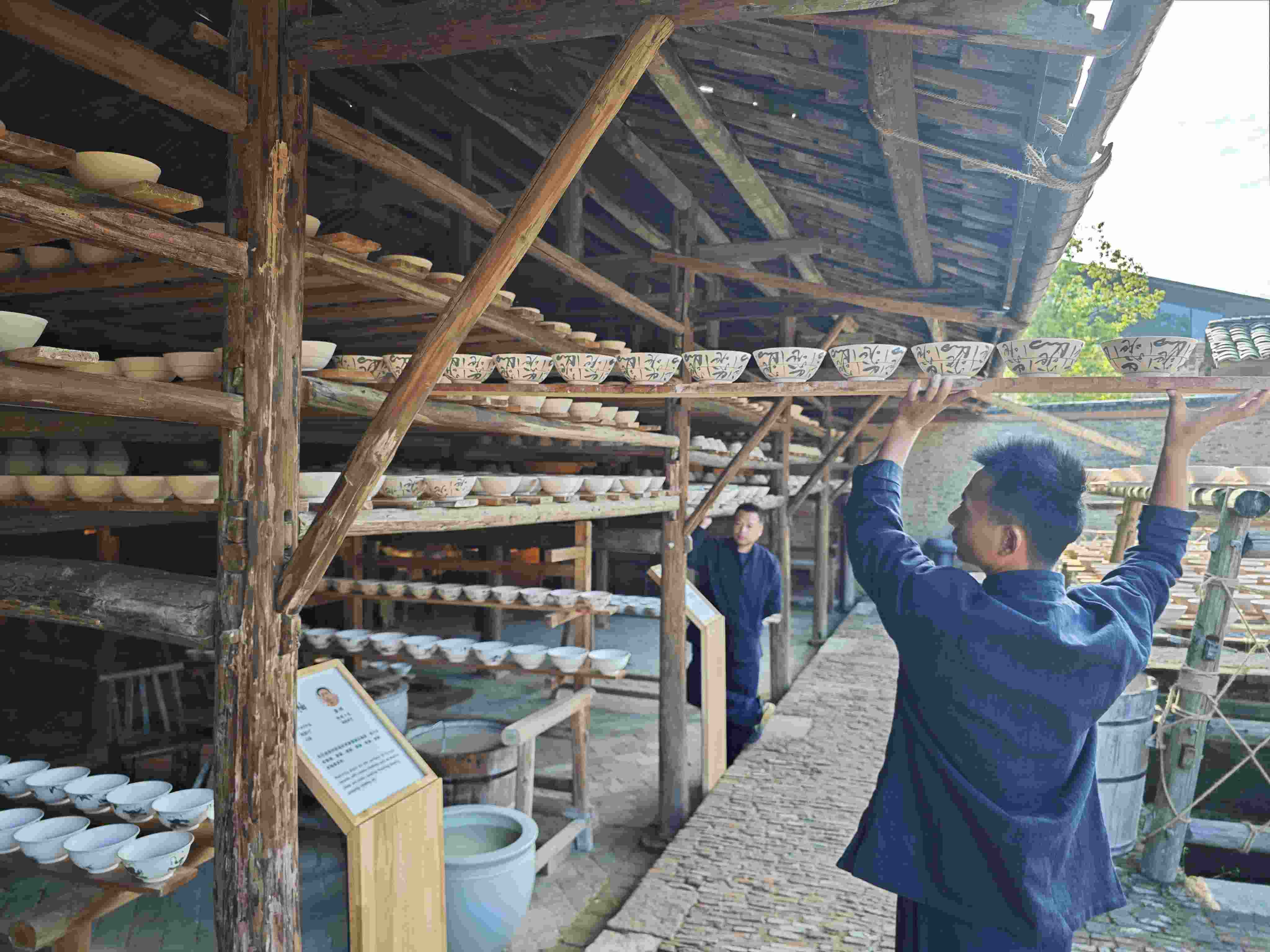 △陶陽(yáng)里歷史文化街區(qū)里，工匠將陶瓷工藝品放到架上晾干。（總臺(tái)央視記者彭漢明拍攝）