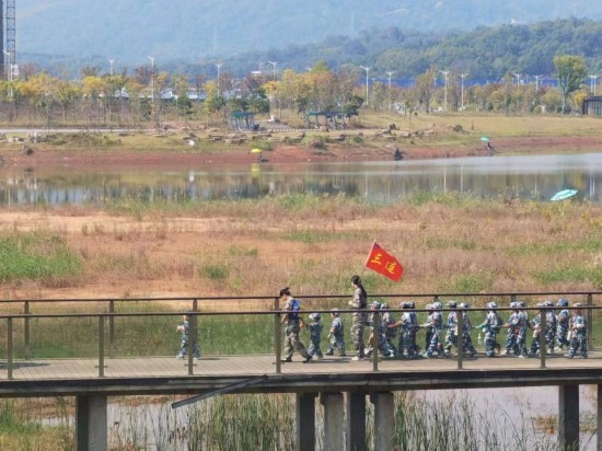 10月24日，秋游的幼兒園小朋友在老師帶領(lǐng)下走在清水塘公園里的木橋上。本報記者 常雯宜攝