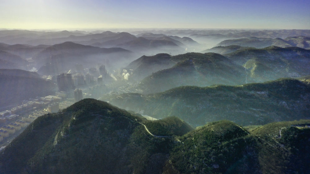 陜西省延安市吳起縣的山山峁峁被茂密的山林覆蓋（2021年12月20日攝，無(wú)人機(jī)照片）。新華社記者 陶明 攝