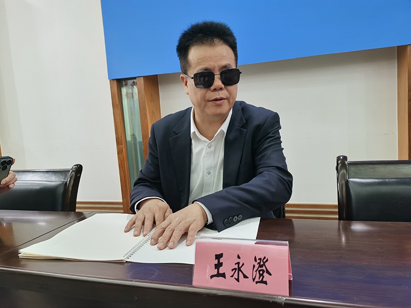 全國(guó)人大代表王永澄正在閱讀盲文版代表建議答復(fù)。本報(bào)記者 張 璁?dāng)z