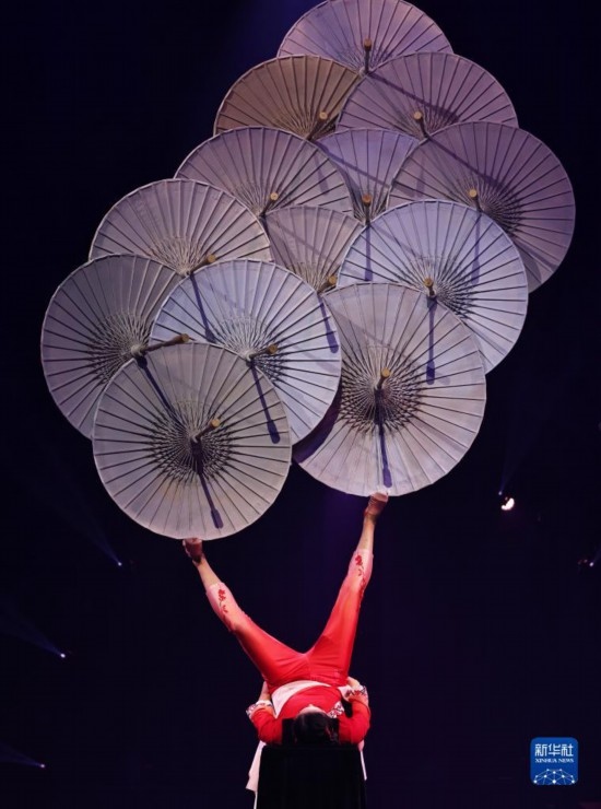 12月8日，演員在法國(guó)巴黎舉行的中國(guó)雜技“奇妙之夜”演出上表演《蹬傘》。新華社記者 高靜 攝