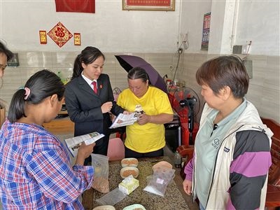  圖⑤：龍圩區(qū)法院法官到群眾家中開展法治宣傳。資料圖片