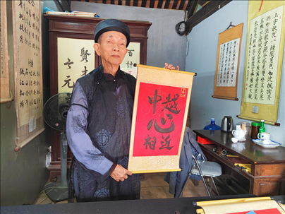 越南首都河內(nèi)文廟內(nèi)，阮明珠展示“中越心相近”書法作品。