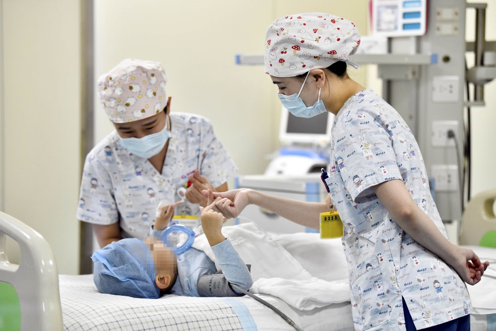 在山東省棗莊市婦幼保健院兒童ICU病房，醫(yī)護(hù)人員為完成靶向治療藥物諾西那生鈉的4歲脊髓性肌萎縮癥患兒加油鼓勁（2022年1月1日攝）。諾西那生鈉注射液是我國首個獲批治療脊髓性肌萎縮癥的進(jìn)口藥物，2019年進(jìn)入中國市場時，每針價格近70萬元。在2021年國家醫(yī)保目錄藥品談判中，以3.3萬元每針的價格進(jìn)入新版醫(yī)保藥品目錄。新華社記者 郭緒雷 攝
