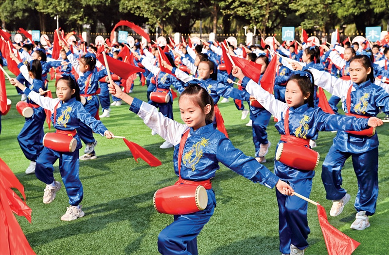 為助推民族地區(qū)基礎(chǔ)教育事業(yè)發(fā)展，廣西重新核定各地中小學(xué)教職工編制，依托全區(qū)編制“周轉(zhuǎn)池”核增事業(yè)編制給各地中小學(xué)，在全面達到國家標(biāo)準的基礎(chǔ)上，進一步統(tǒng)籌優(yōu)化和動態(tài)調(diào)整各區(qū)域、學(xué)校、學(xué)段間編制資源。圖為2023年11月29日，南寧市濱湖路小學(xué)舉行主題為“逐夢新時代 健體向未來”的體育文化節(jié)，孩子們正在跳腰鼓舞。 新華社記者 周華/攝