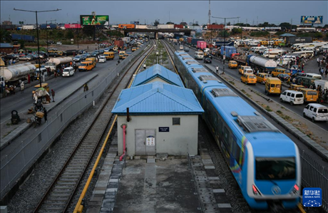 3月4日，在尼日利亞拉各斯，一列輕軌藍(lán)線列車行駛至公路交通擁堵路段附近。新華社記者 韓旭 攝