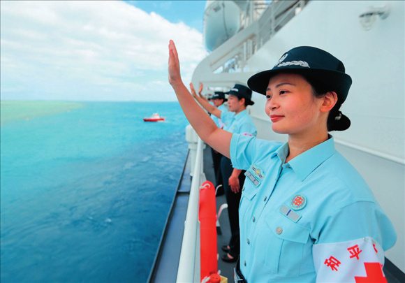 中國海軍“和平方舟”號醫(yī)院船結(jié)束訪問湯加時，任務(wù)官兵中的文職人員向歡送人群揮手告別（2023年8月4日攝）。徐巍攝/本刊