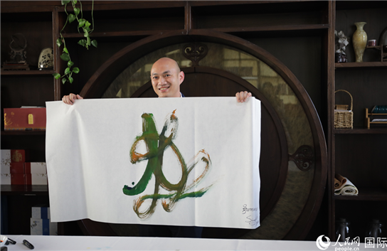 老撾駐華大使館三秘明君參加《五百筆·瀾湄合作》集體藝術(shù)創(chuàng)作。人民網(wǎng)王婧攝。