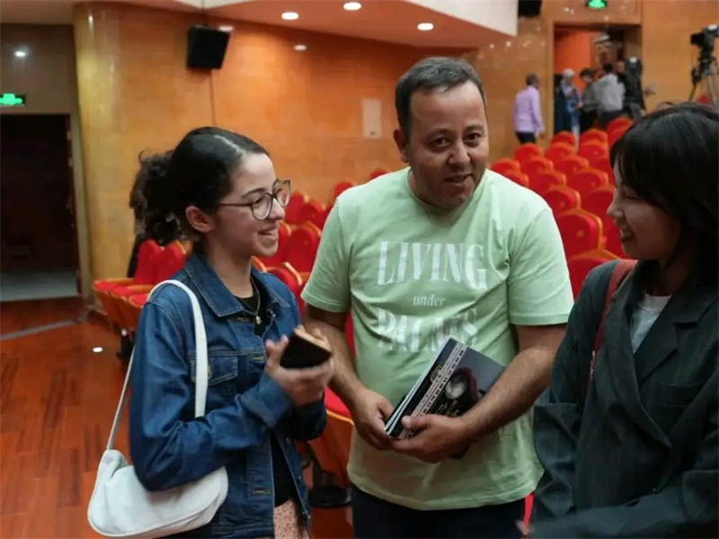 阿爾及利亞市民拉納·艾薩尼和她父親現(xiàn)場聆聽中阿交響樂演出 。蘇州交響樂團(tuán)供圖