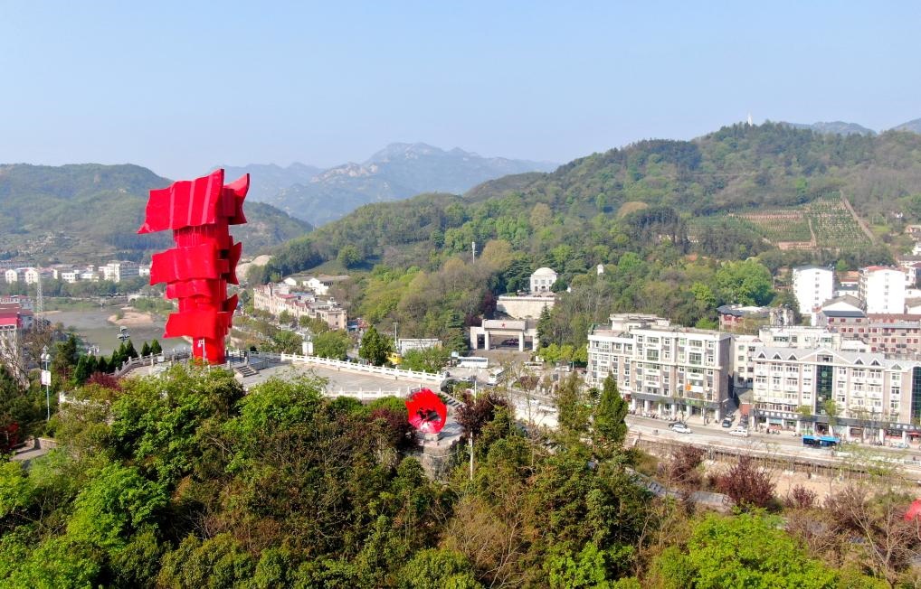 這是2021年4月9日拍攝的鄂豫皖蘇區(qū)首府革命博物館附近的英雄山上的“紅旗飄飄”主題雕塑（無人機(jī)照片）。新華社發(fā)
