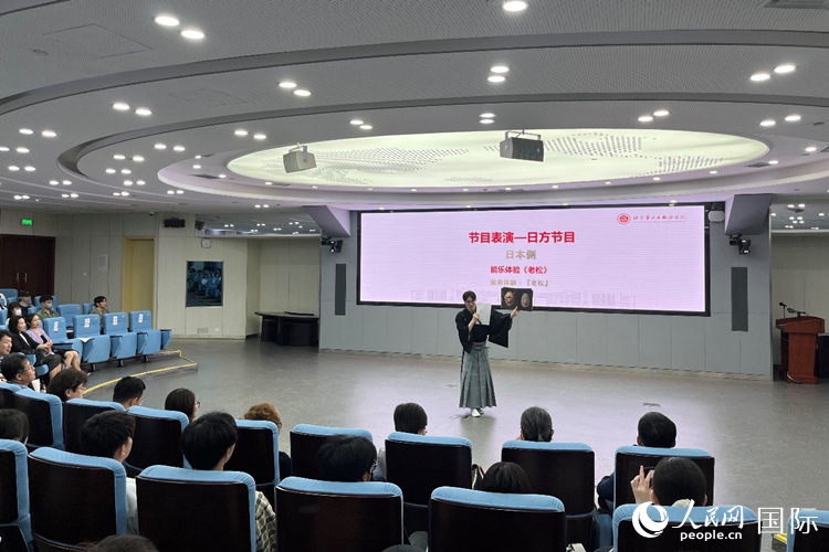 日本大學(xué)生介紹能樂知識。人民網(wǎng)記者 陳思攝