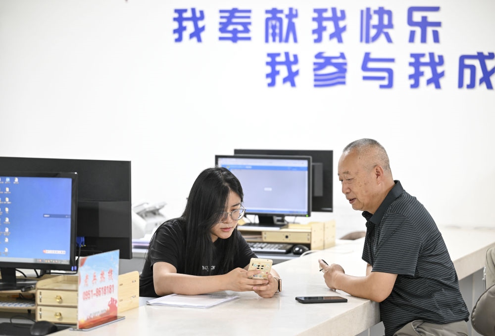 6月20日，在長城花園社區(qū)黨群服務(wù)中心，工作人員幫助居民辦理業(yè)務(wù)。