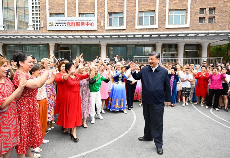2022年7月13日，習(xí)近平總書(shū)記在新疆烏魯木齊市天山區(qū)固原巷社區(qū)考察時(shí)，向各族群眾揮手致意。