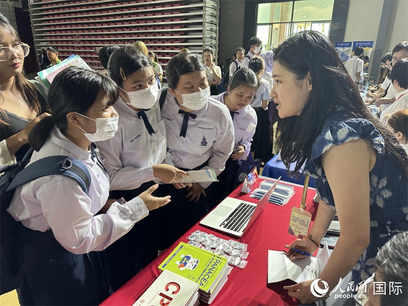 來自泰國的學生、家長在教育展臺前咨詢。人民網(wǎng)記者 簡承淵攝