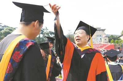 2017年6月22日，李德仁（右一）參加武漢大學(xué)畢業(yè)典禮并為畢業(yè)生撥穗。