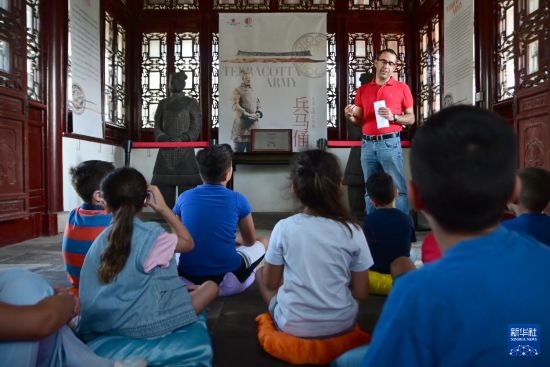 7月4日，在馬耳他桑塔露琪亞市的中國古典園林“靜園”，人們聆聽關(guān)于兵馬俑的講解。新華社發(fā)（喬納森·博格 攝）