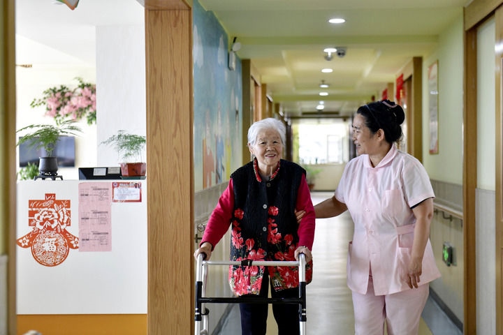 2024年5月25日，在山東省日照市東港區(qū)石臼街道日照幸福護(hù)理院，工作人員在陪護(hù)老人。新華社記者 郭緒雷 攝