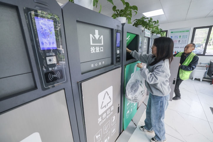 2024年4月10日，在浙江省湖州市吳興區(qū)飛英街道新華府小區(qū)內(nèi)，居民在垃圾分類(lèi)智能系統(tǒng)的指導(dǎo)下進(jìn)行垃圾分類(lèi)投放，居民的投放情況將實(shí)時(shí)匯總到智慧服務(wù)平臺(tái)，會(huì)有相應(yīng)的積分獎(jiǎng)勵(lì)。新華社記者 徐昱 攝