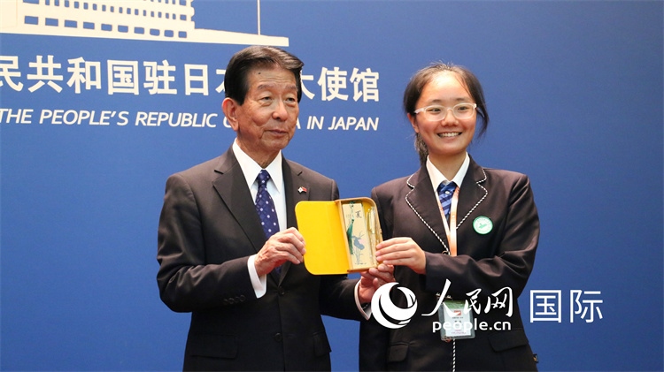 中國(guó)小大使向日本永旺1%俱樂部理事長(zhǎng)森美樹贈(zèng)送當(dāng)?shù)靥厣Y品。人民網(wǎng) 許可攝