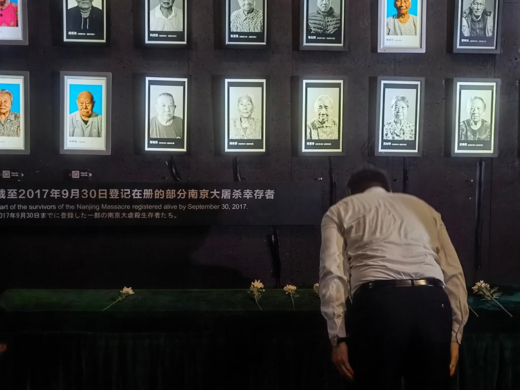 7月18日，人們向離世的南京大屠殺幸存者獻花、鞠躬。新華社記者邱冰清 攝