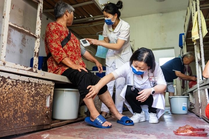 2024年7月30日，在湖南省湘潭縣河口中學(xué)安置點(diǎn)，醫(yī)務(wù)人員為受洪水影響而轉(zhuǎn)移安置的群眾檢查身體。 新華社記者 陳思汗 攝