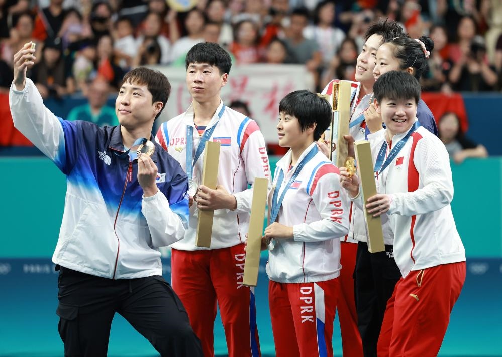 冠軍中國組合王楚欽（右三）/孫穎莎（右一）、亞軍朝鮮組合李正植（左二）/金琴英（左三）、季軍韓國組合林鐘勛（左一）/申裕斌在巴黎奧運會乒乓球混雙頒獎儀式上合影（2024年7月30日攝）。新華社記者 劉續(xù) 攝