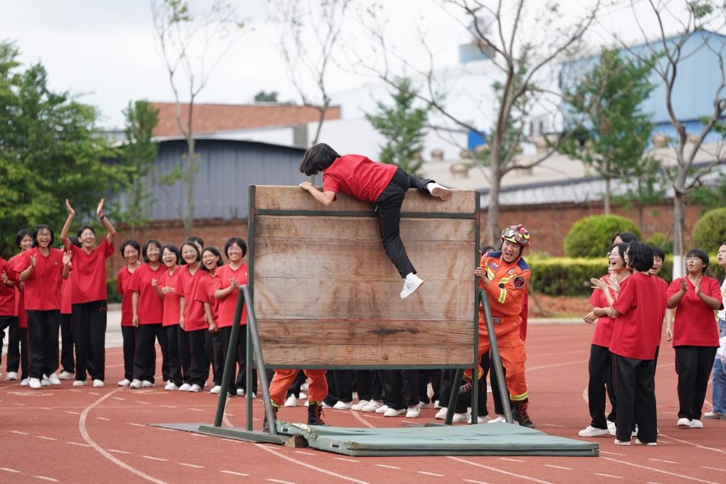 云南麗江華坪女子高級中學(xué)學(xué)生在體驗(yàn)翻越障礙板。新華社記者陳欣波 攝