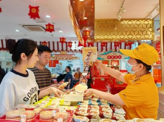 北京稻香村一家門店內(nèi)，售貨員向顧客展示新上市的月餅禮盒。（受訪者供圖）