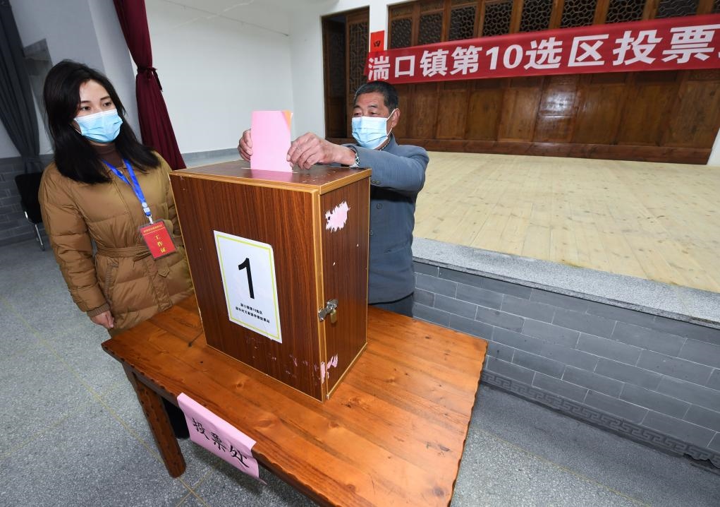 2021年12月14日，在浙江省杭州市臨安區(qū)湍口鎮(zhèn)迎豐村的基層投票點，村民在參加投票，村級監(jiān)察聯(lián)絡(luò)員監(jiān)票。新華社記者 徐昱 攝