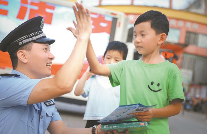 ▲7月10日，江西省吉安市公安局吉州分局組織民警深入轄區(qū)開(kāi)展安全宣傳，民警向小朋友講解防溺水知識(shí)。朱文杰攝