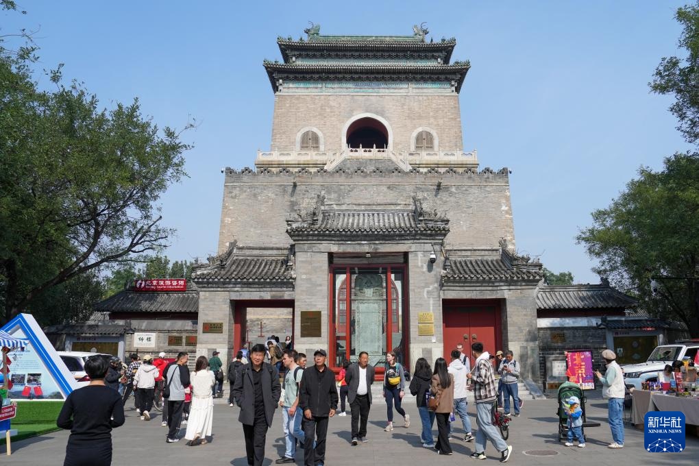 國(guó)慶假期，中外游客在北京鐘樓前參觀游覽。新華社記者 鞠煥宗攝