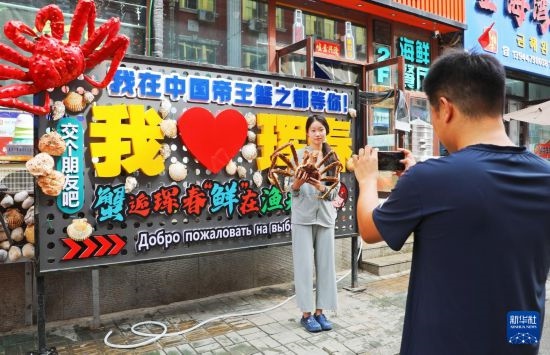9月21日，游客在吉林省琿春市一處帝王蟹元素主題裝飾前拍照留念。新華社發(fā)